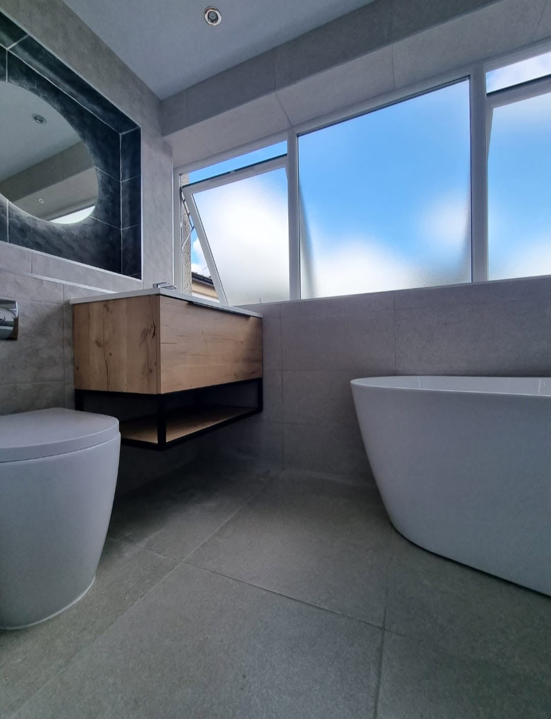 Freestanding bath with floating wood vanity